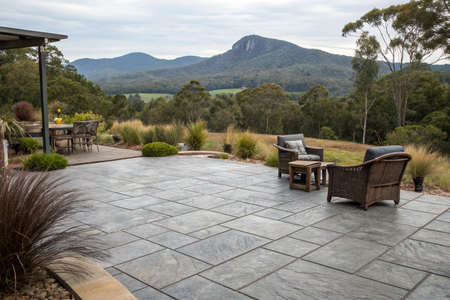 backyard patio area with stamped concrete in ashlar slate pattern, outdoor furniture arranged on the surface